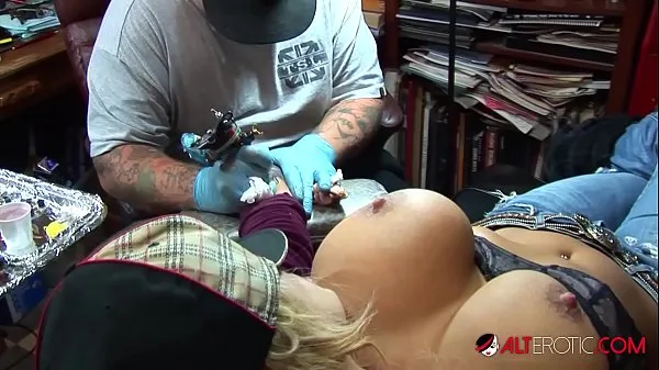 Hot Busty blonde pornstar pulls out her huge tits while getting a tattoo on her wrist warm Movies